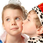 girl in princess costume being kissed by little prince