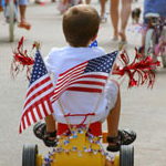 boy riding tricycle decorated with flags