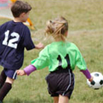 two children playing soccer