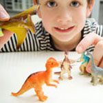 boy playing with toy dinosaurs